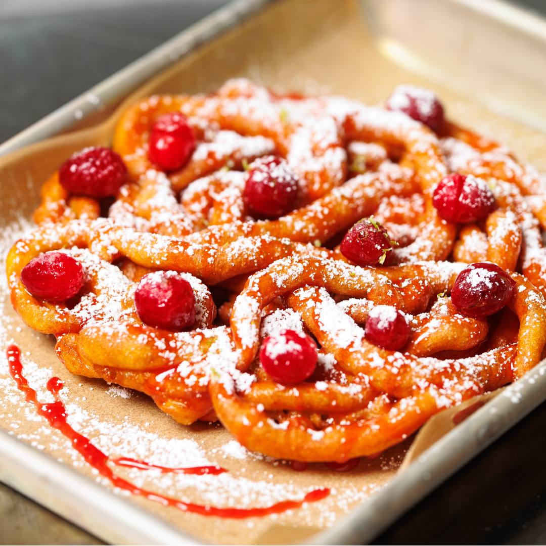 Funnel cake studded wtih cranberries and drizzled with cranberry carmel syrup and powdered sugar
