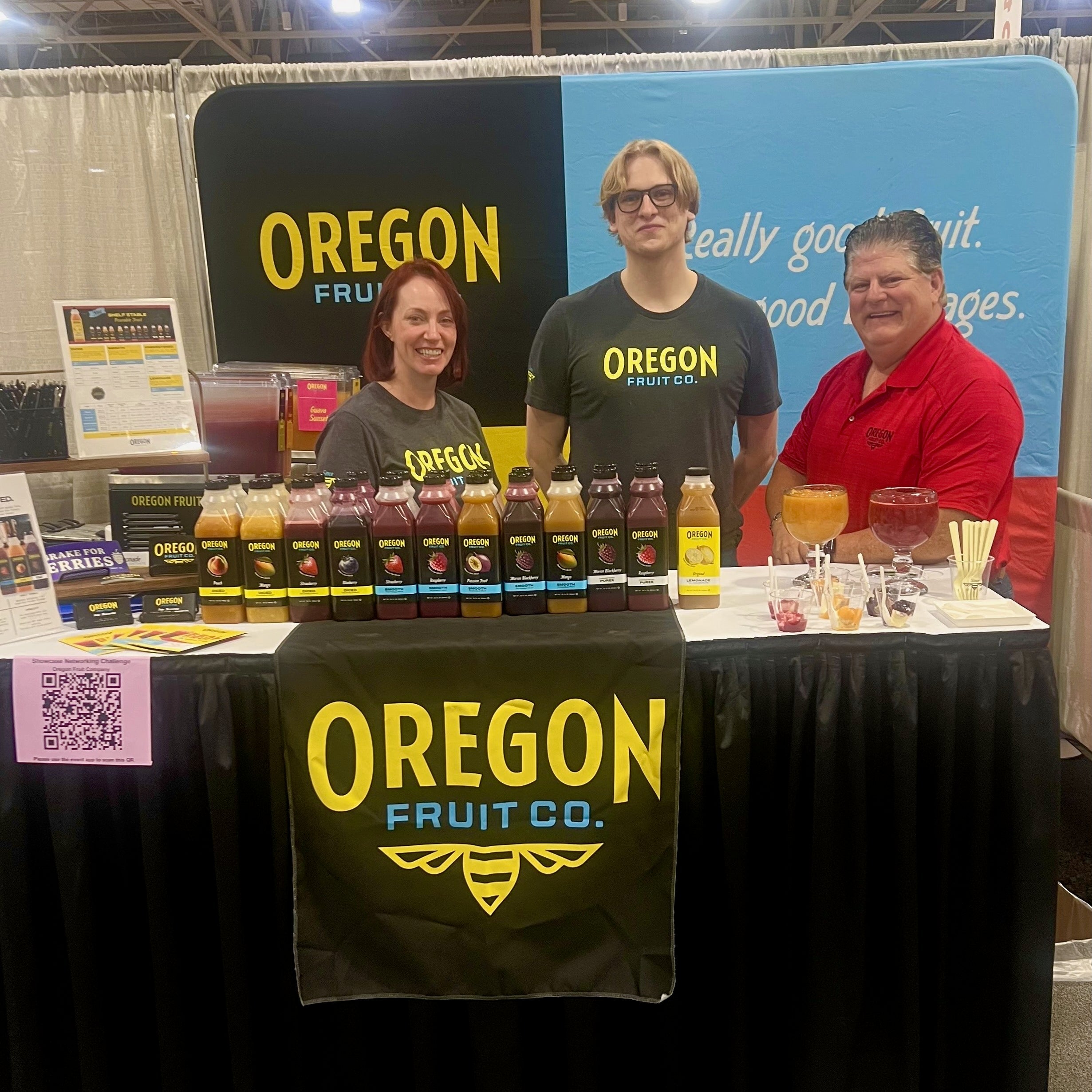 Three Oregon Fruit employees stand behind a booth