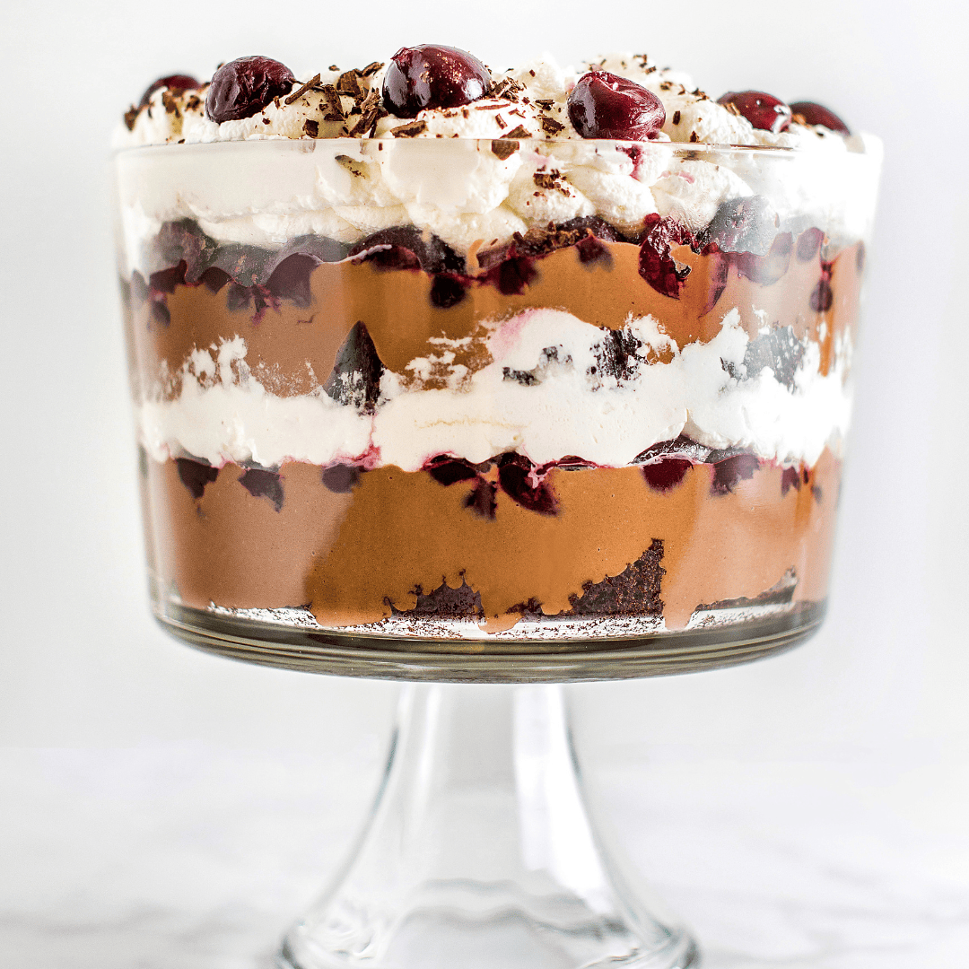 a layered black forest trifle in a glass trifle dish