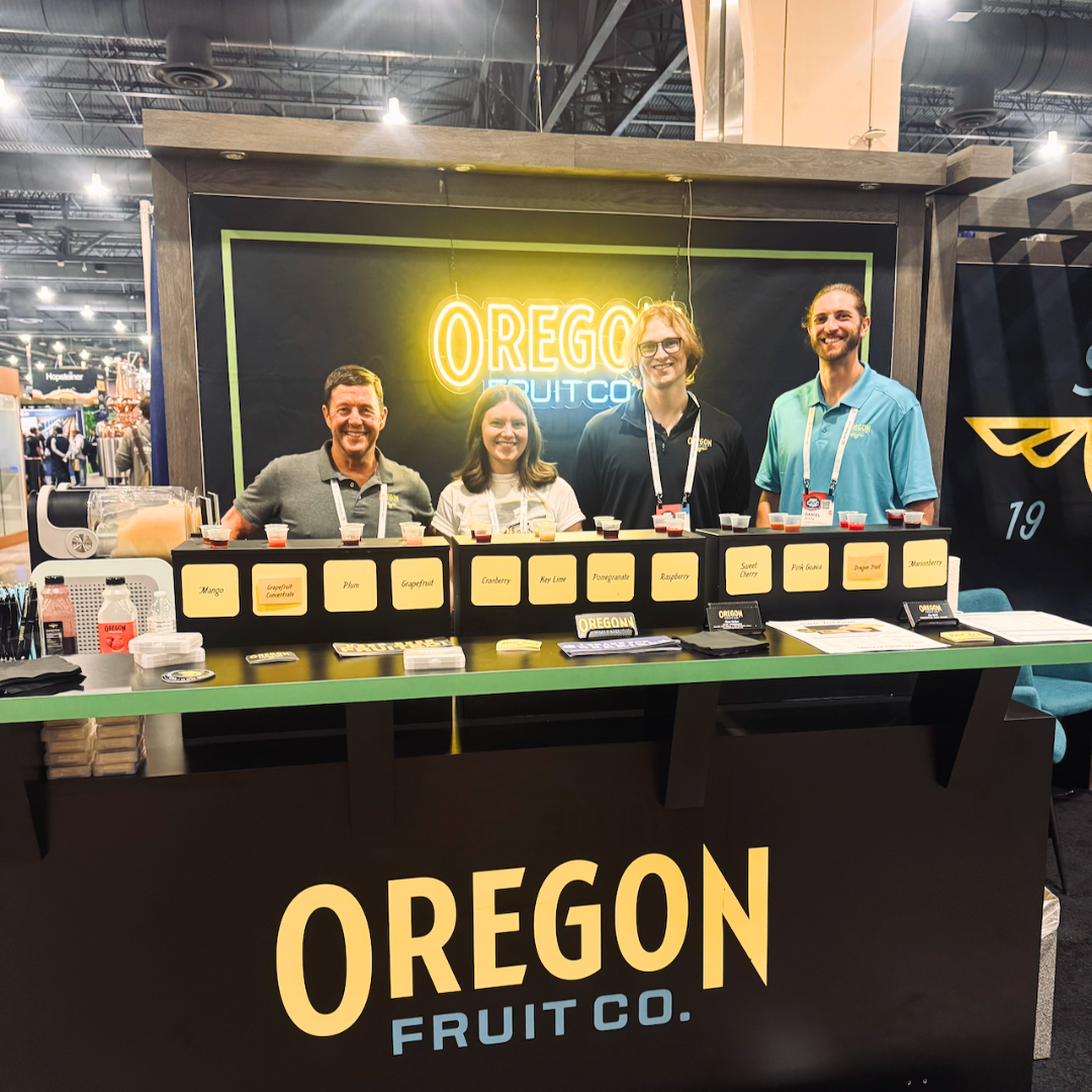 Four people stand behind a booth with aseptic fruit puree samples
