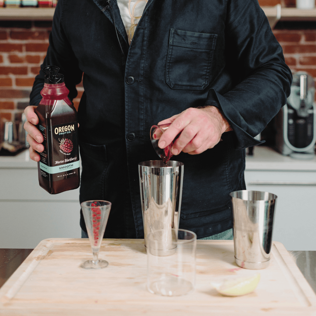 A man mixes a cocktail with Oregon Fruit Pourable Fruit