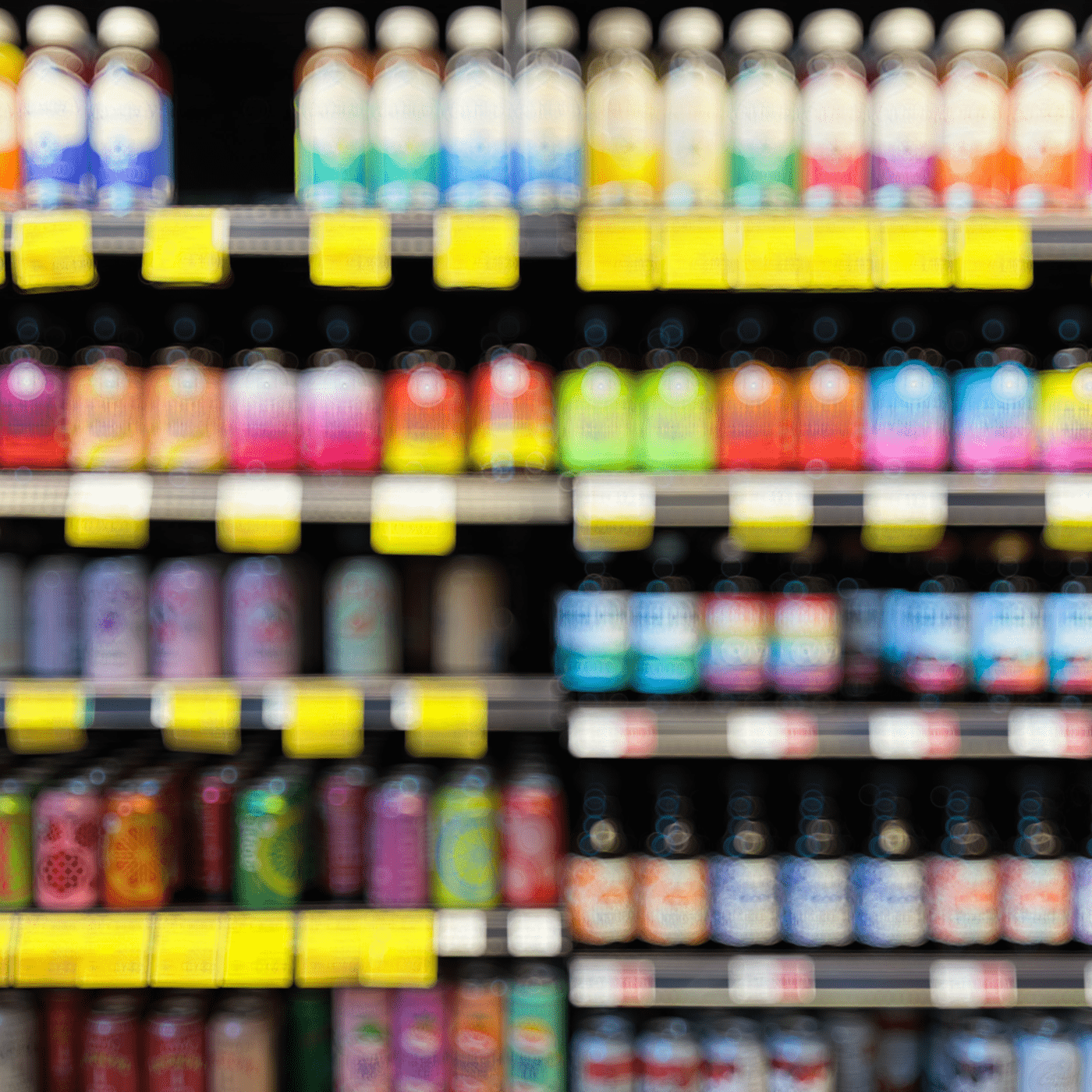An out of focus display shelf of single serving beverages in a market