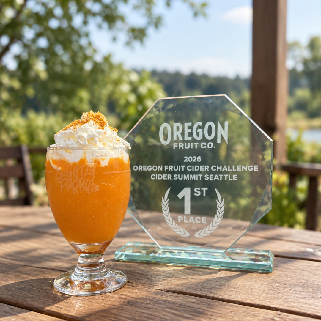 an orange slushie with cream topper sits next to a glass award on a table
