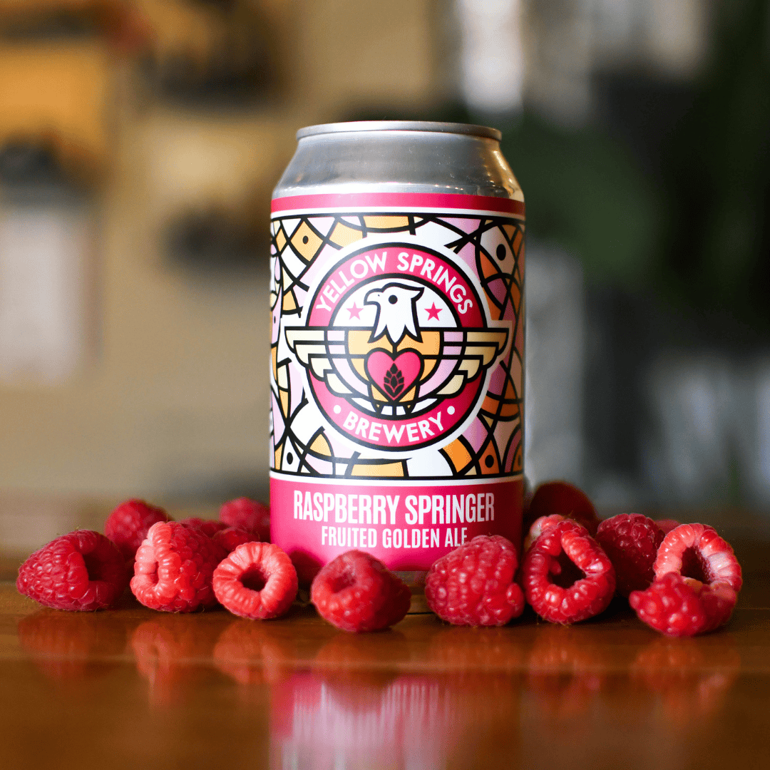 Bright pink can of Raspberry Springer beer surrounded by raspberries