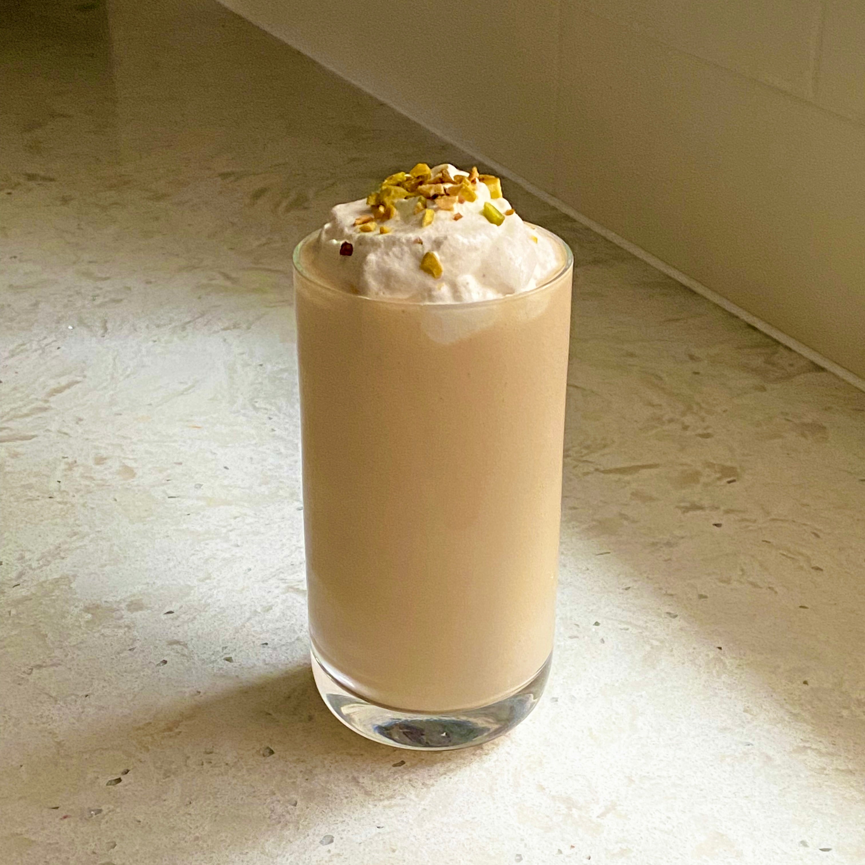 glass of mango lassi with whipped cream