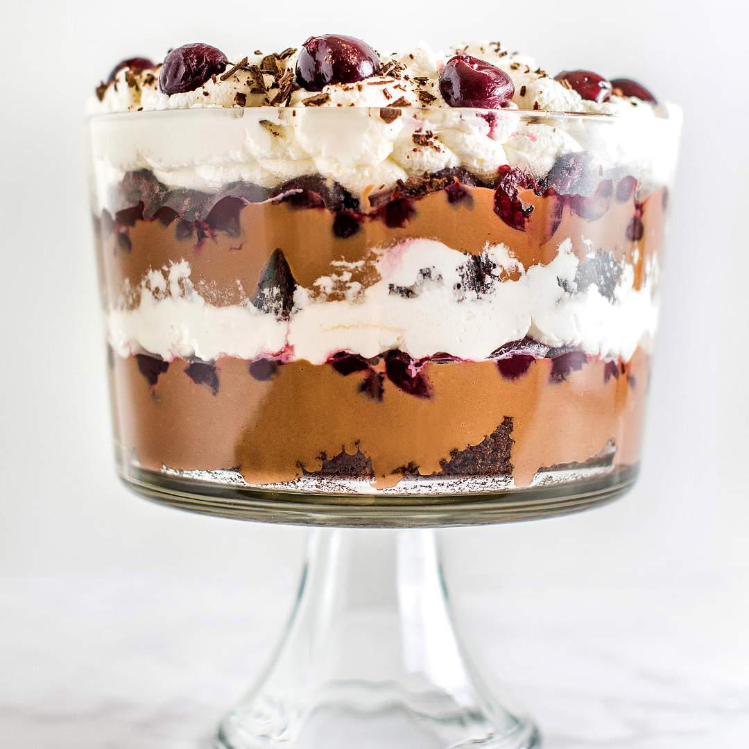 a layered black forest trifle in a glass trifle dish