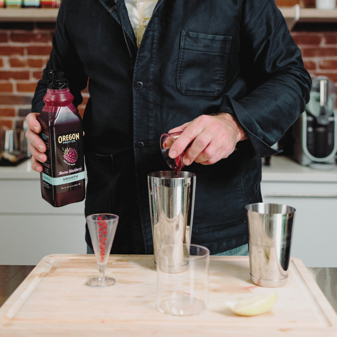 A man mixes a cocktail with Oregon Fruit Pourable Fruit