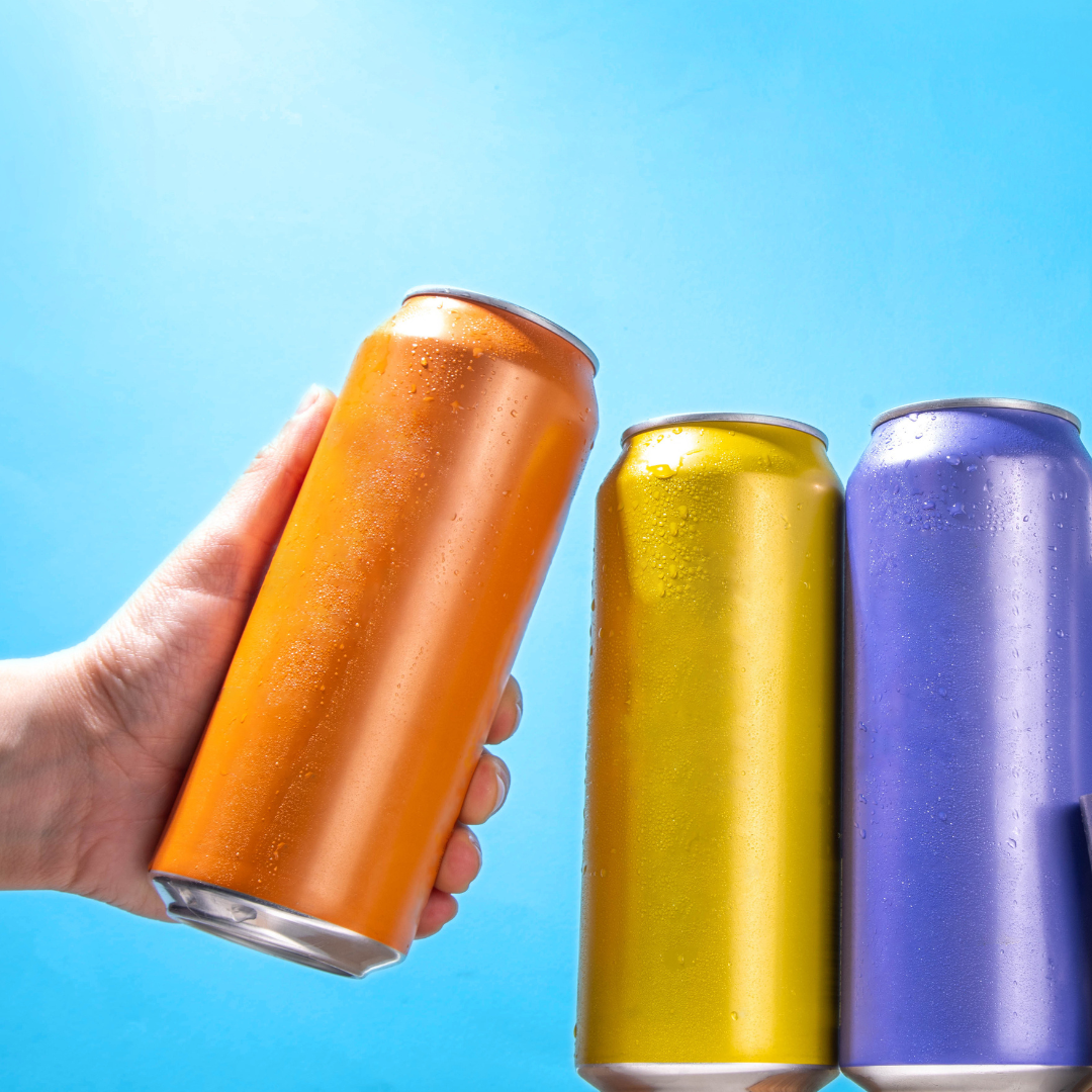A hand grabs an unlabeled orange can, next to yellow and blue cans.