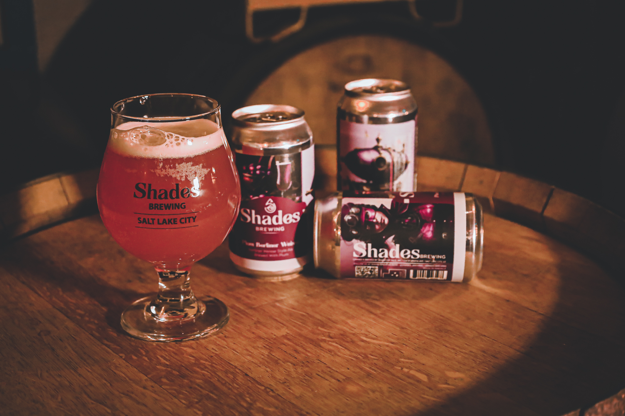 Glasses and cans of Shades Plum Berliner Weisse beer